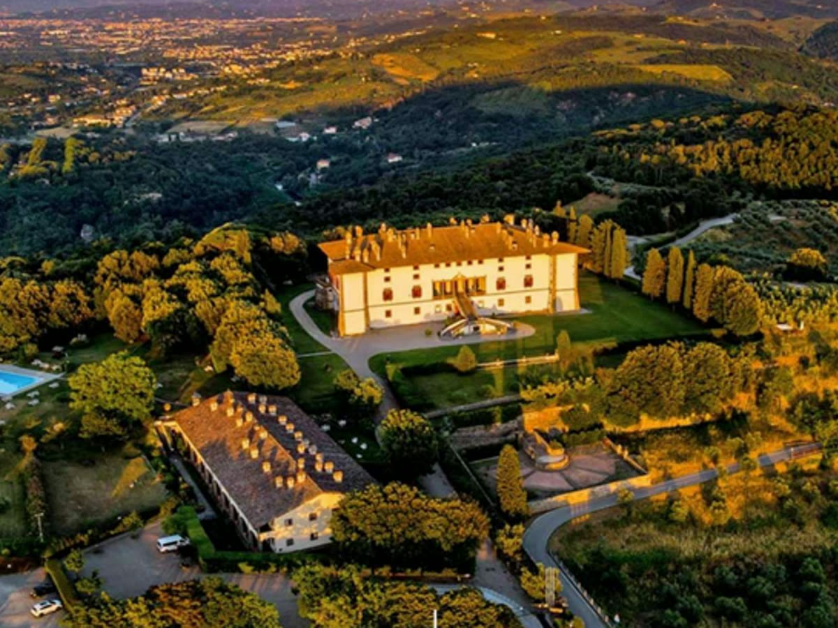 La tenuta vista dall'alto: il corpo padronale, il borgo e i giardini fra i boschi della collina.