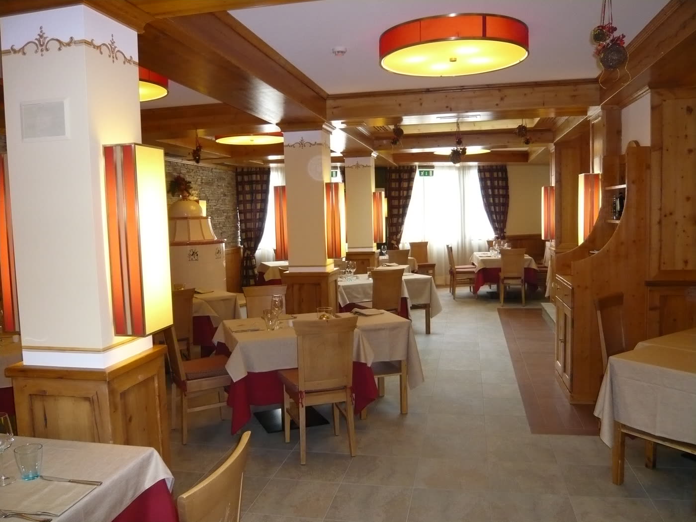 Sala del ristorante con boiserie in larice e colonne.