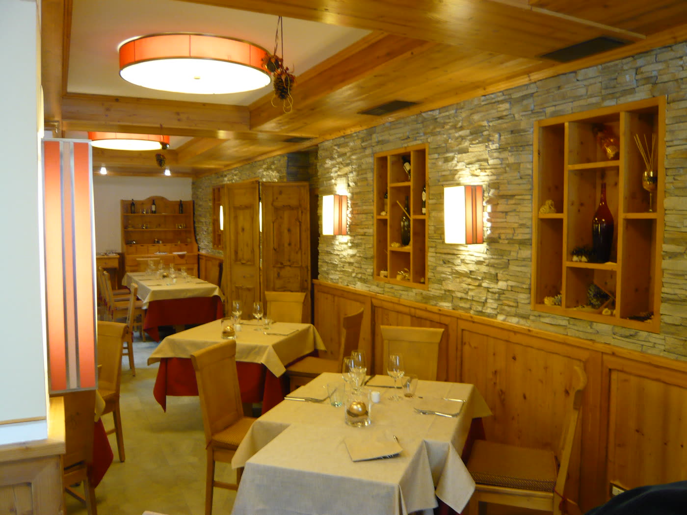 Angolo del ristorante con parete in pietra a vista.