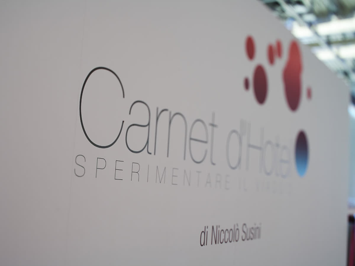 Camera di Carnet d'Hôtel: testata in teak, rete di ottone dietro il letto e lanterne accese ai lati.
