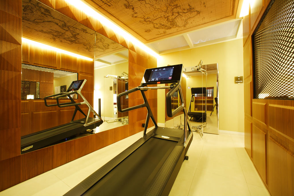 Zona fitness della camera, con il soffitto rivestito da una carta geografica.